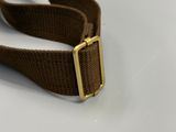 un gros plan sur une ceinture marron avec une boucle dorée