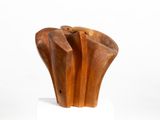 wooden sculpture of a hand holding a piece of wood on top of a white base
