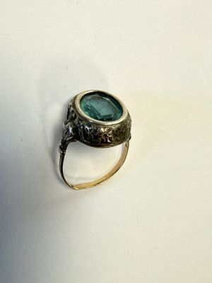 une bague sertie d'une pierre verte sur un fond blanc