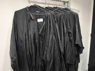 trois chemises noires suspendues à un portant dans une pièce