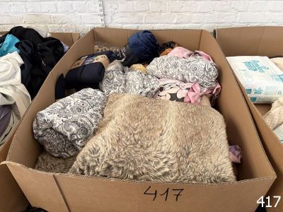 une boîte en carton remplie de nombreux vêtements et couvertures
