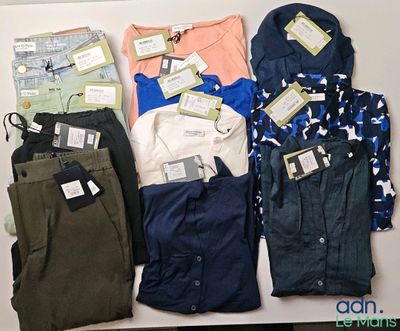 several pairs of pants and shirts are laid out on a table