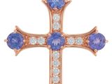 un pendentif en forme de croix en or rose, orné de pierres bleues et blanches