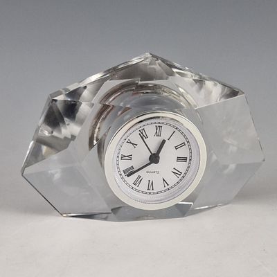 a glass clock with roman numerals on the face