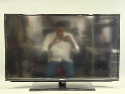 un homme en train de se prendre en photo dans le miroir d'un téléviseur à écran plat