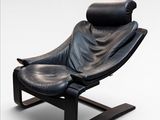 fauteuil inclinable en cuir noir avec repose-pieds, sur fond blanc