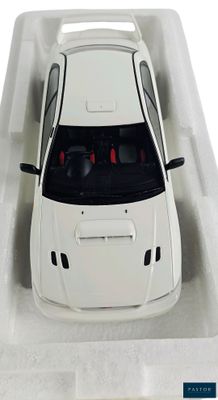a white toy car in a white box on a white surface