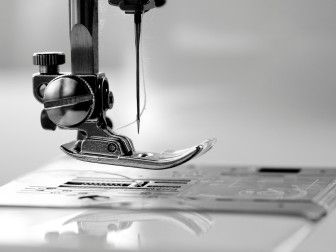photographie en noir et blanc d'une machine à coudre posée sur une table