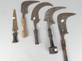 several old knives are lined up on a white surface