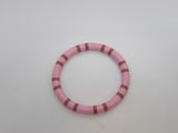 a close up of a pink bracelet on a white surface