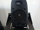 a speaker that is sitting on a stand in front of a monitor