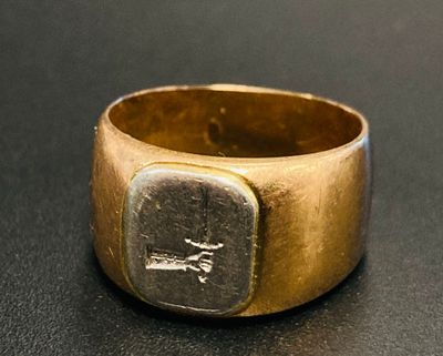 une image représentant une bague en or sur laquelle figure une inscription