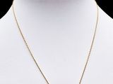 un collier et des boucles d'oreilles en or sertis de pierres roses, présentés sur un mannequin