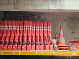 a shelf full of red fire extinguisors and orange cones