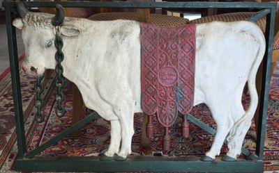 a statue of a cow that is standing on a rug