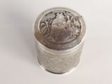 an old silver box sitting on top of a white surface