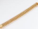 a gold bracelet with a chain on a white background