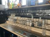 many wine glasses and a remote control on the bar