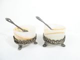 two cups with spoons in them sitting on a table