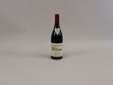 une bouteille de vin posée sur une surface blanche