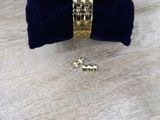 a gold bracelet and a pair of earrings sitting on a table