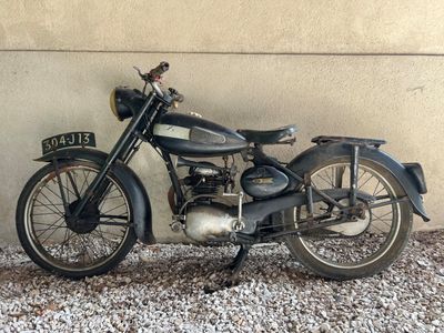 une moto noire garée contre un mur