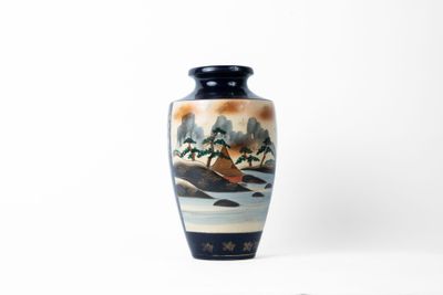 un vase avec un tableau posé sur une table