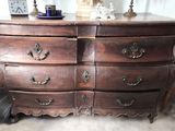 une commode en bois sur laquelle est posée une lampe