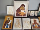 many framed pictures of different religious icons on a table