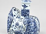 a blue and white vase with a cat on it