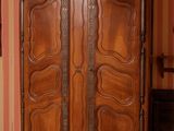 a wooden armoire in the corner of a room