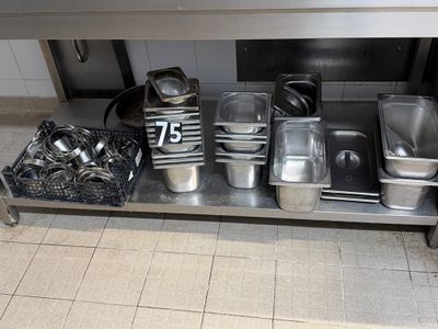 many pots and pans sitting on a stainless steel table