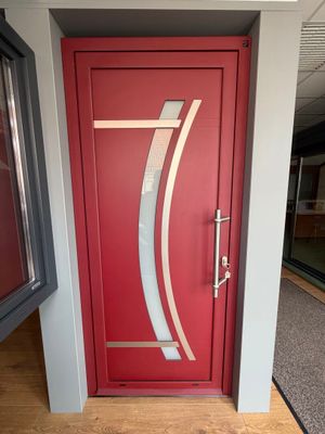 une porte rouge ornée d'un motif argenté