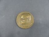 une pièce d'or sur laquelle figure l'image d'un homme