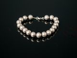 a close up of a silver bracelet on a black surface