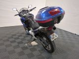 a blue motorcycle that is parked on a checkered floor