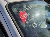 a sticker on the windshield of a car with a red heart on it