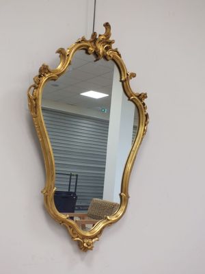 un miroir doré accroché au mur d'une pièce