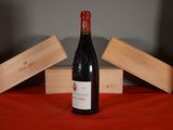 a bottle of wine sitting on a table next to two wooden boxes