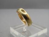 a gold ring sitting on top of a clear stand