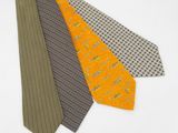 trois cravates de couleurs différentes posées sur une surface blanche, sur fond blanc