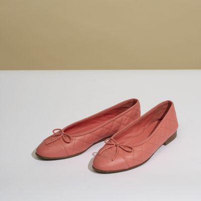 une paire de chaussures roses posée sur une table blanche