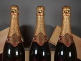 two bottles of champagne sitting on top of a wooden box