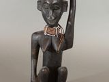 statue of a man with a hat on his head holding a piece of wood