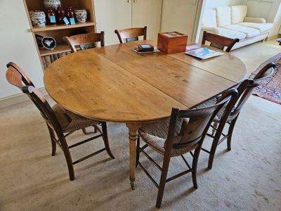 a table and chairs in a room with a bookcase