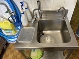 a stainless steel sink in the corner of a kitchen