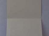 an open white card on a table with a blue background