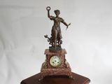 une statue de femme tenant une horloge sur une table