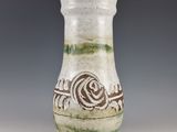 a white vase with a green and brown design on it