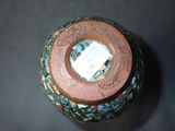 a vase with a tag on it sitting on a table
